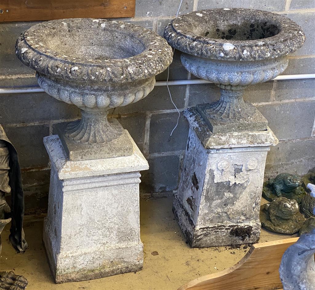 A pair of reconstituted stone campana garden urns and pedestals, 56cm diameter, height 99cm